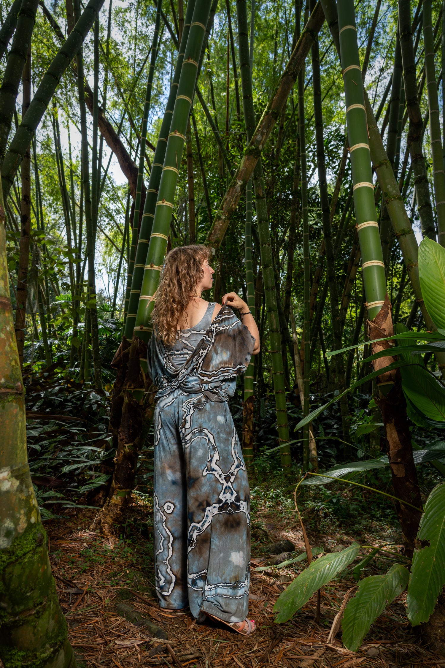 Hand-dyed two piece set featuring wide leg palazzo pants and a twist top in earthy gray, black and brown tones, photographed in a bamboo forest