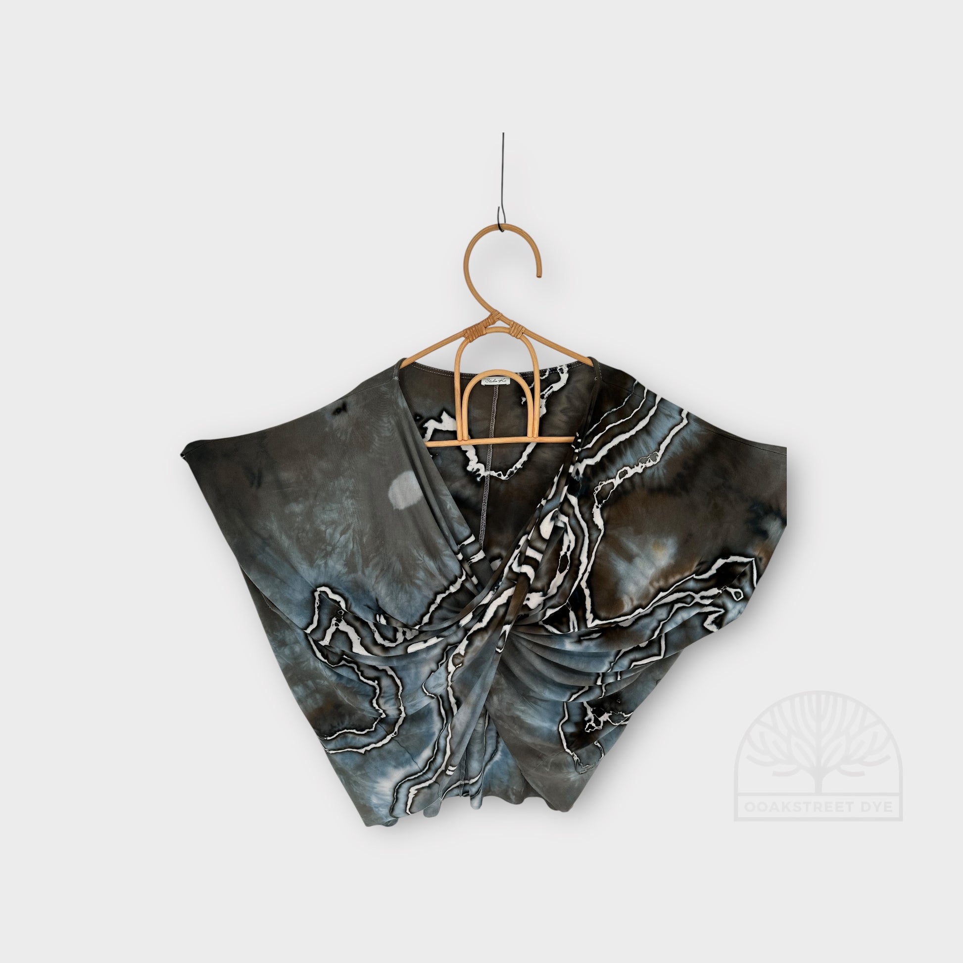 Close-up of Driftwood twist top set, hand-dyed bamboo viscose fabric with blue-gray, charcoal, and weathered brown marbling hanging. 